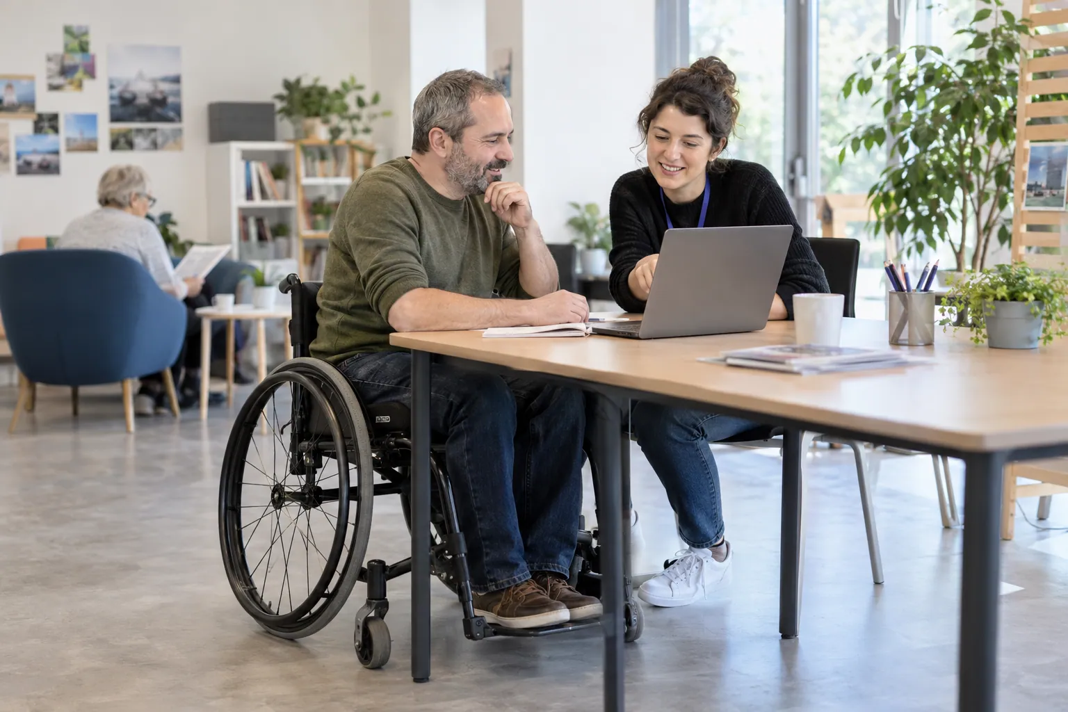 Illustration photoréaliste : usager et accompagnatrice devant un ordinateur dans un espace numérique accessible